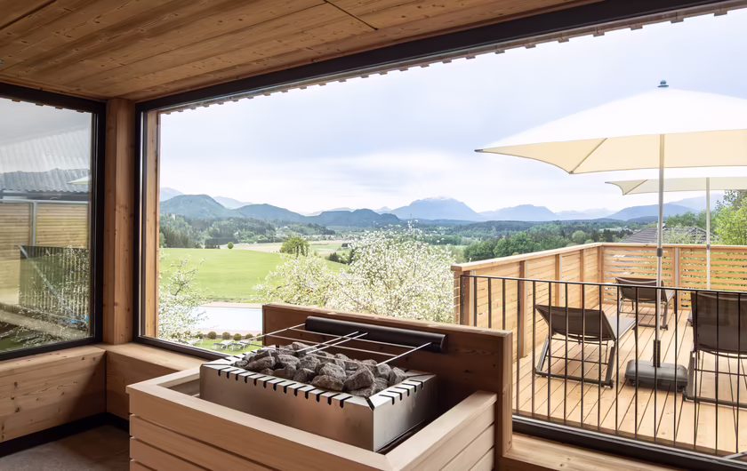 Panoramasauna aus Holz mit Ausblick auf das Bergpanorama