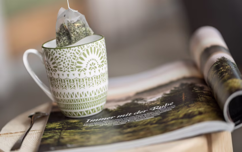Detailfoto grün / weiße Teetasse mit Kräutertee Beutel