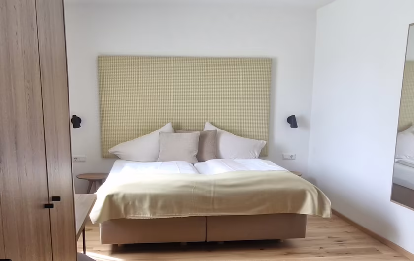 Zimmer mit Doppelbett, Spiegel, Schrank und Sitzecke